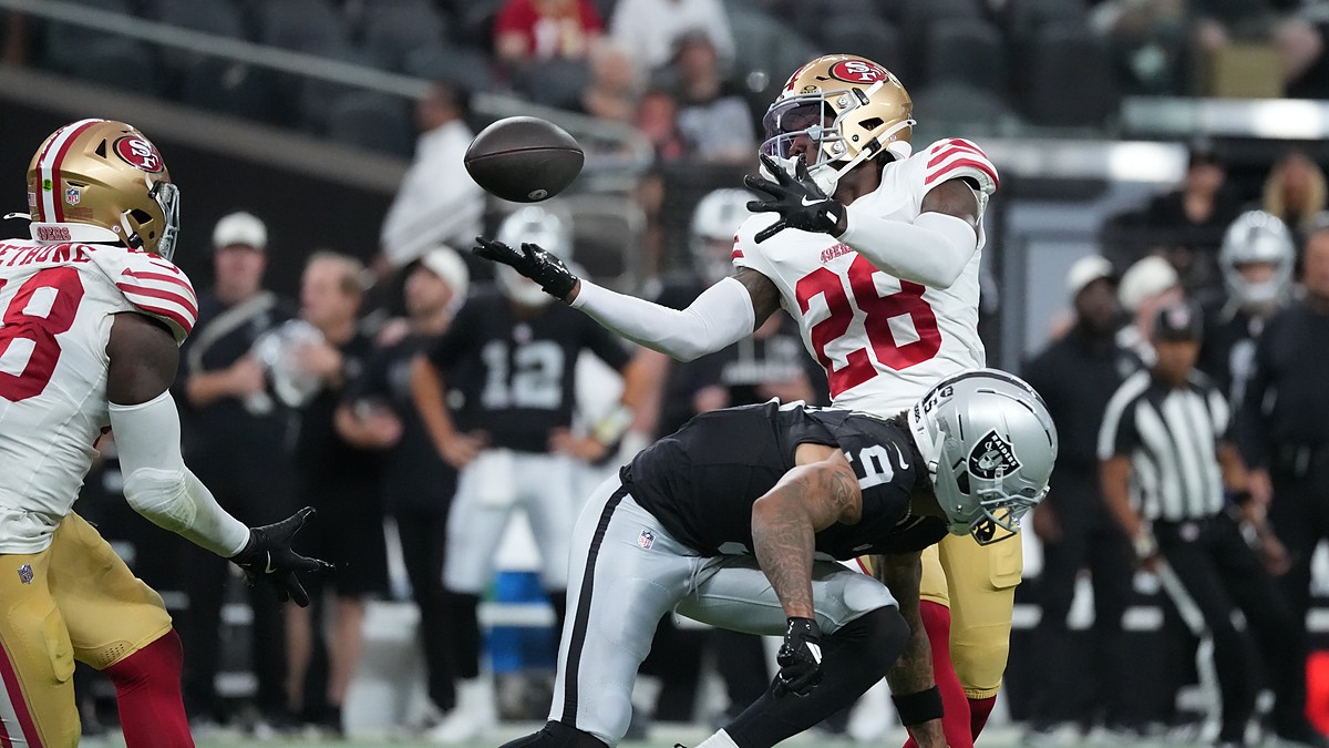 San Francisco 49ers cornerback Darrell Luter Jr. reaches back to break up a pass as the ball floats free.