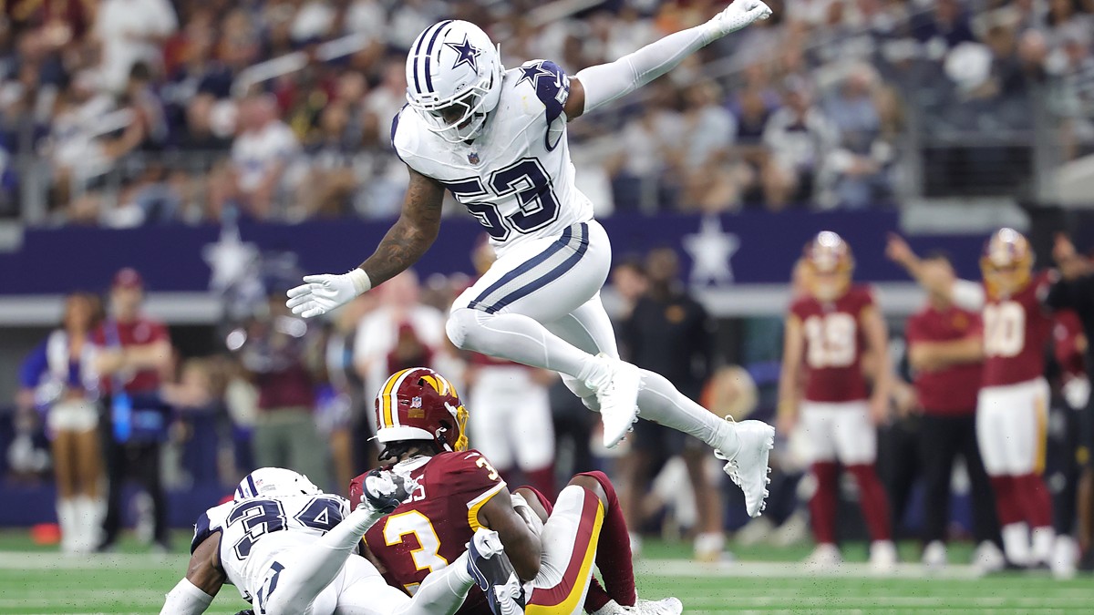 Dallas Cowboys linebacker Dee Winters hurdles a tackle as a teammate brings down a Commanders receiver.