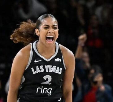 Las Vegas Aces guard Deja Kelly screams in celebration as fans cheer behind her.