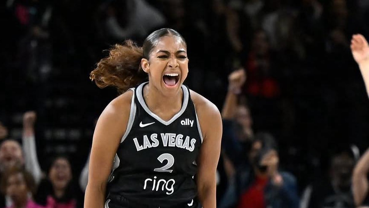 Las Vegas Aces guard Deja Kelly screams in celebration as fans cheer behind her.