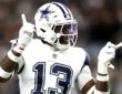 Dallas Cowboys linebacker DeMarvion Overshown smiles and gestures with both hands after a play.
