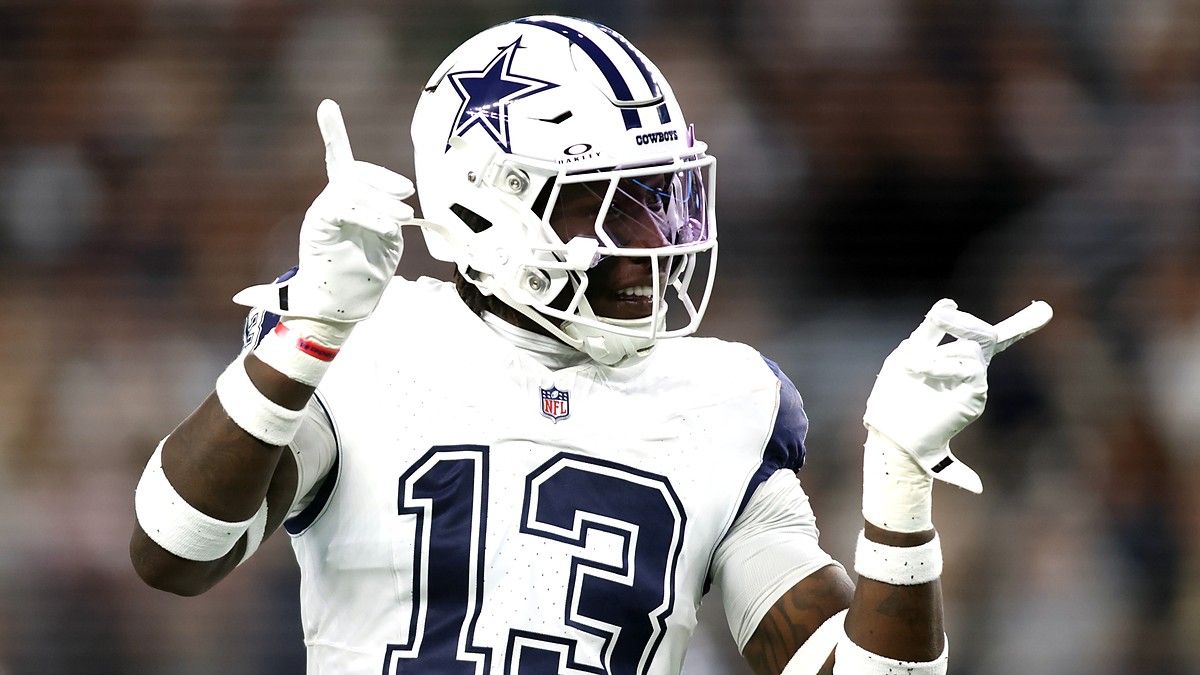 Dallas Cowboys linebacker DeMarvion Overshown smiles and gestures with both hands after a play.