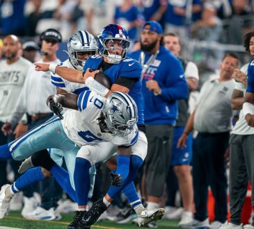 Dallas Cowboys linebacker DeMarvion Overshown drives New York Giants quarterback Jaxson Dart out of bounds near the sideline.