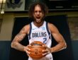 Dallas Mavericks center Dereck Lively II yells while gripping a basketball during a media day photo shoot.