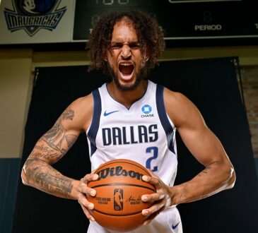 Dallas Mavericks center Dereck Lively II yells while gripping a basketball during a media day photo shoot.