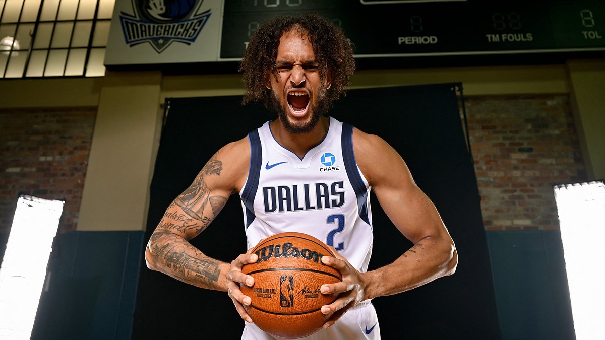 Dallas Mavericks center Dereck Lively II yells while gripping a basketball during a media day photo shoot.