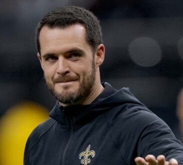 New Orleans Saints quarterback Derek Carr walks the field in a team hoodie during pregame at Caesars Superdome.
