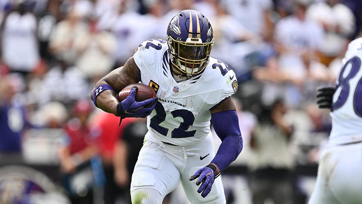 Baltimore Ravens running back Derrick Henry carries the ball upfield with a teammate blocking to his left.