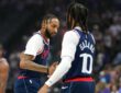 LA Clippers forward Derrick Jones Jr. reaches out to slap hands with teammate Darius Garland before tipoff.
