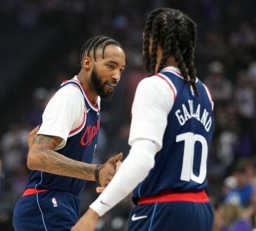 LA Clippers forward Derrick Jones Jr. reaches out to slap hands with teammate Darius Garland before tipoff.