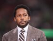 Alt Text: ESPN analyst Desmond Howard wears a headset microphone on the broadcast set before a College Football Playoff game.