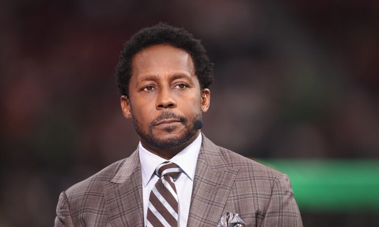 Alt Text: ESPN analyst Desmond Howard wears a headset microphone on the broadcast set before a College Football Playoff game.