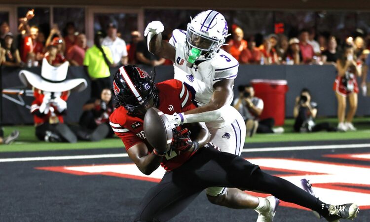 Abilene Christian defensive back Dillon Williams, No. 3, reaches in on Texas Tech tight end Terrance Carter Jr. as the ball comes loose.