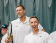 Former Dallas Mavericks forward Dirk Nowitzki smiles and high-fives an opponent across the net at a celebrity tennis match.