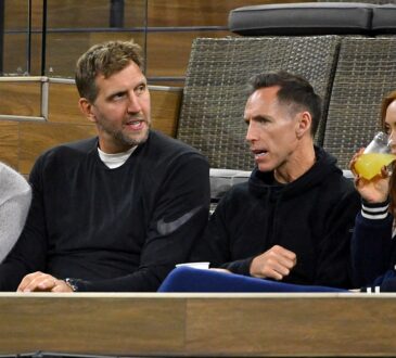 Former Dallas Mavericks teammates Dirk Nowitzki and Steve Nash talk while watching a tennis match from their seats.