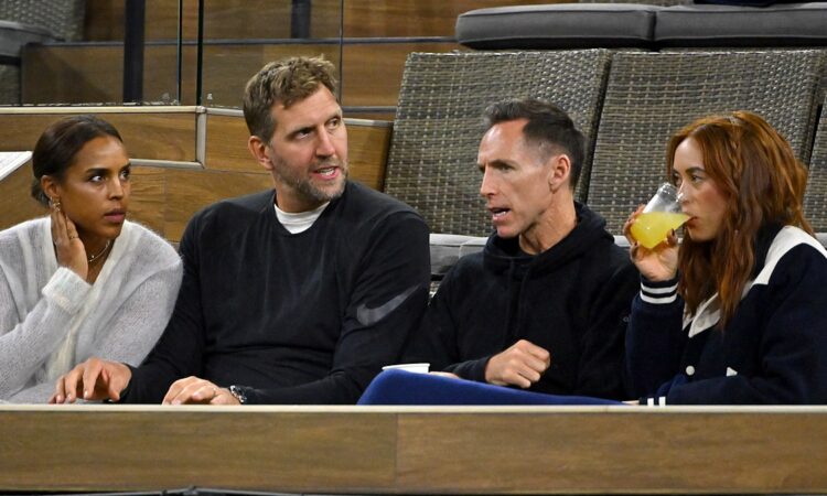 Former Dallas Mavericks teammates Dirk Nowitzki and Steve Nash talk while watching a tennis match from their seats.