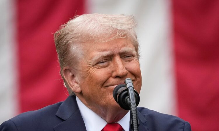 President Donald Trump speaks at a microphone in front of an American flag at a Pentagon memorial event.