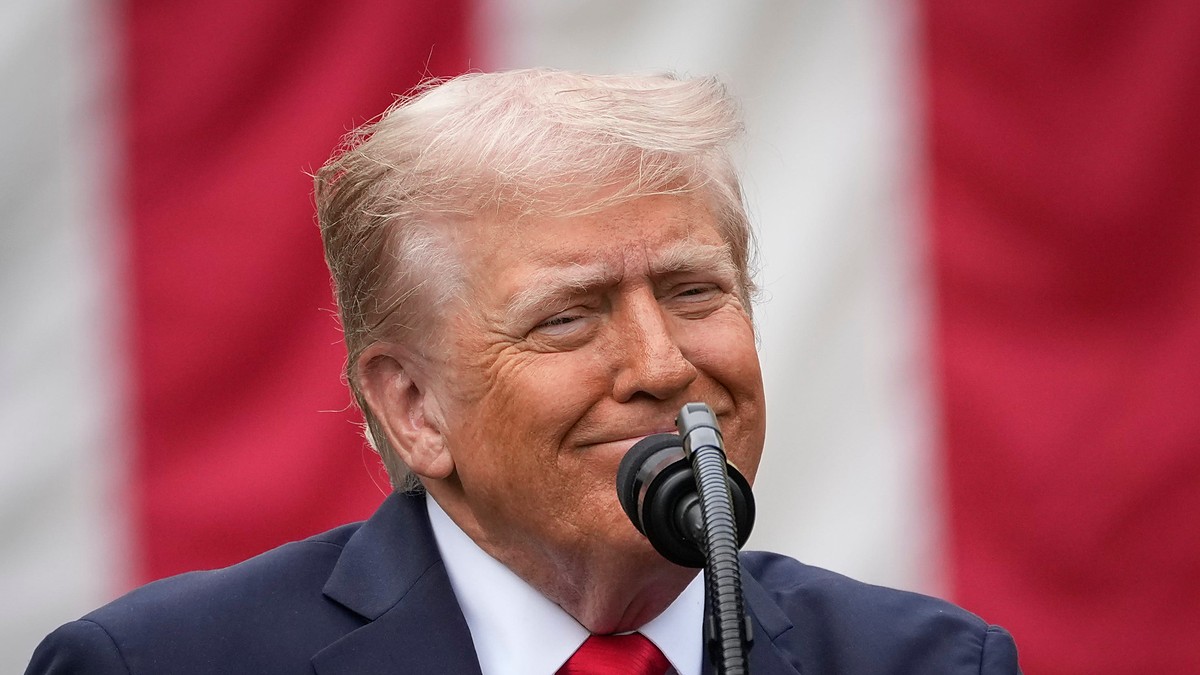 President Donald Trump speaks at a microphone in front of an American flag at a Pentagon memorial event.
