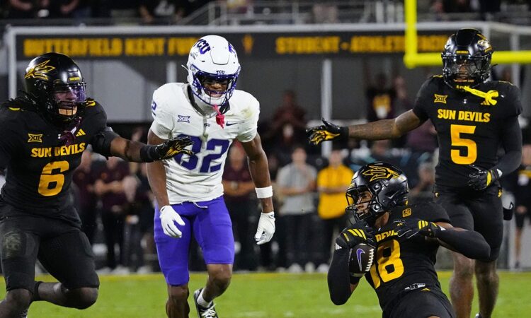 TCU wide receiver Dozie Ezukanma looks back as Arizona State defenders converge after an interception.