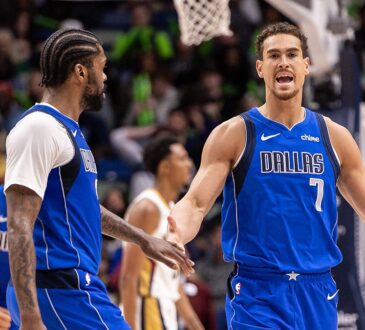 Dallas Mavericks forward Dwight Powell shouts as he slaps hands with forward Naji Marshall on the court.