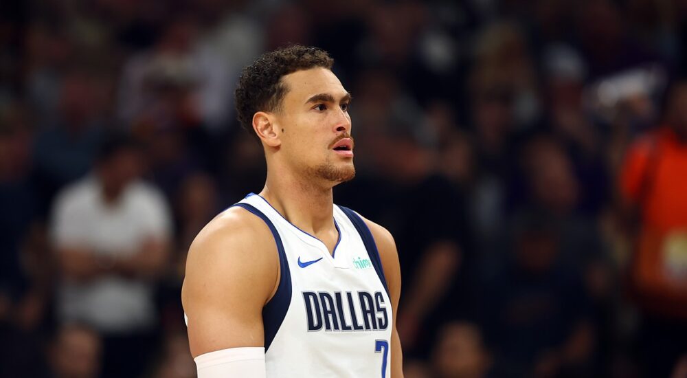 Dallas Mavericks forward Dwight Powell looks on during a game in his white Dallas jersey with a sleeve on his right arm.