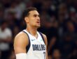 Dallas Mavericks forward Dwight Powell looks on during a game in his white Dallas jersey with a sleeve on his right arm.