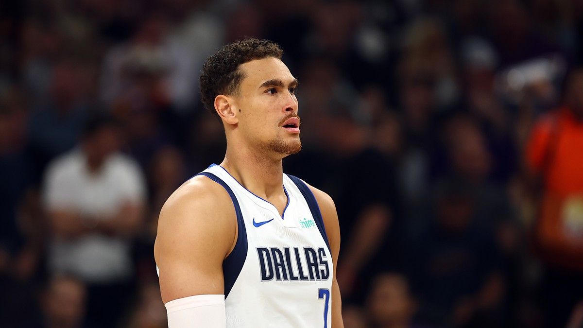 Dallas Mavericks forward Dwight Powell looks on during a game in his white Dallas jersey with a sleeve on his right arm.