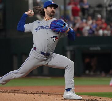 Toronto Blue Jays pitcher Dylan Cease strides toward the plate mid-delivery against Texas at Globe Life Field.