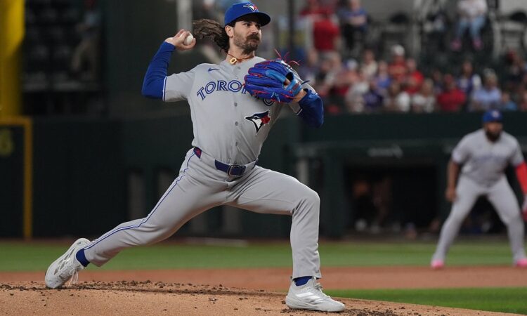 Toronto Blue Jays pitcher Dylan Cease strides toward the plate mid-delivery against Texas at Globe Life Field.