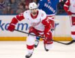 Detroit Red Wings center Dylan Larkin skates up ice with his stick extended during a game against the Rangers.