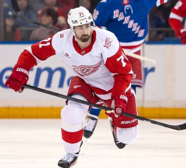 Detroit Red Wings center Dylan Larkin skates up ice with his stick extended during a game against the Rangers.