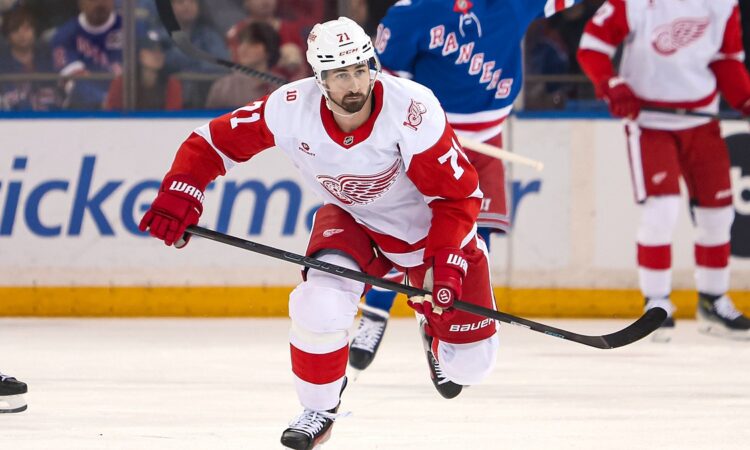 Detroit Red Wings center Dylan Larkin skates up ice with his stick extended during a game against the Rangers.