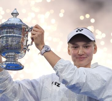 Elena Rybakina raises the U.S. Open trophy overhead as sparks fall behind her.