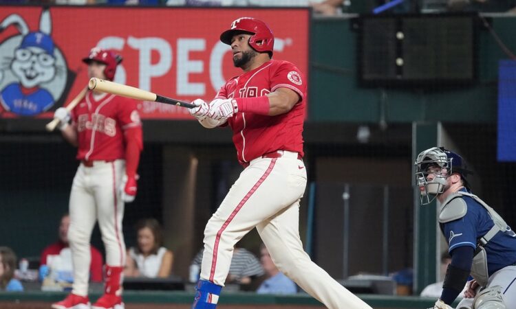 Texas Rangers catcher Elias Díaz, No. 35, follows through on a swing in a red alternate jersey.