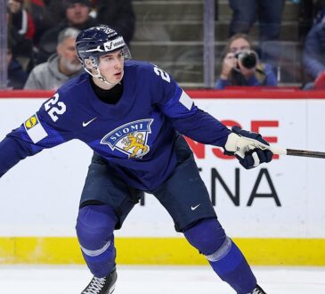 Finland forward Emil Hemming, No. 22, follows through with a broken stick after a shot as the blade skids away.