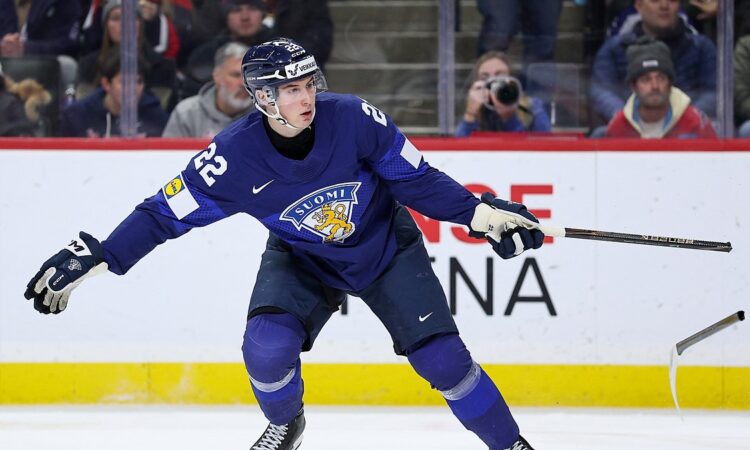Finland forward Emil Hemming, No. 22, follows through with a broken stick after a shot as the blade skids away.
