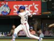 Texas Rangers center fielder Evan Carter, No. 32, follows through on a swing at Globe Life Field.