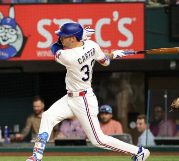 Texas Rangers center fielder Evan Carter, No. 32, follows through on a swing at Globe Life Field.