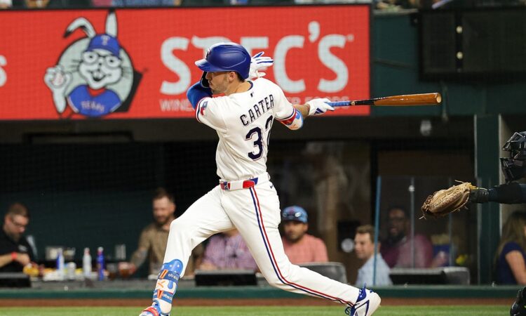 Texas Rangers center fielder Evan Carter, No. 32, follows through on a swing at Globe Life Field.