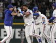 Texas Rangers players swarm Ezequiel Duran on the infield after his game-winning hit.