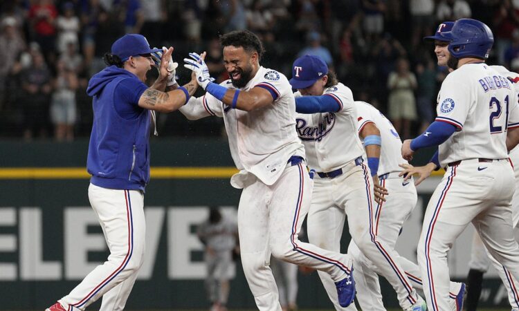 Texas Rangers players swarm Ezequiel Duran on the infield after his game-winning hit.