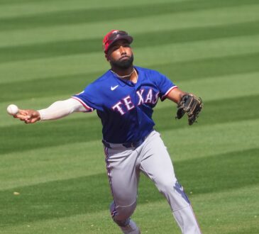 Texas Rangers infielder Ezequiel Durán, No. 20, fires a sidearm throw to first base on the run.