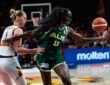 Australia center Ezi Magbegor, wearing a black face mask, reaches for the ball as Belgium’s Emma Meesseman defends.