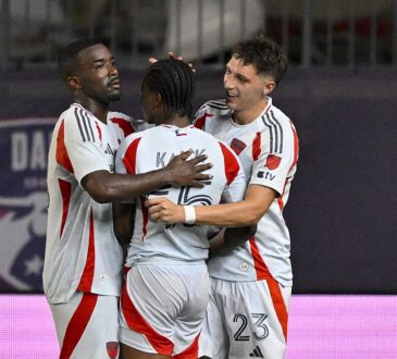 FC Dallas players Shaq Moore, Kaick Ferreira, and Logan Farrington embrace after a goal at Toyota Stadium.
