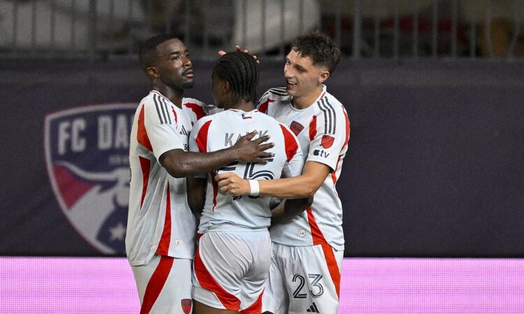 FC Dallas players Shaq Moore, Kaick Ferreira, and Logan Farrington embrace after a goal at Toyota Stadium.
