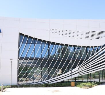 The blue FIFA wordmark mounted on the white facade of a curved glass FIFA office building.