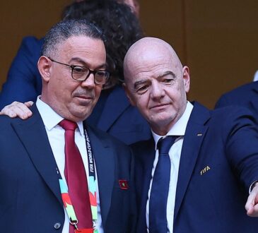 Royal Moroccan Football Federation president Fouzi Lekjaa stands with FIFA president Gianni Infantino in the stands before a match.