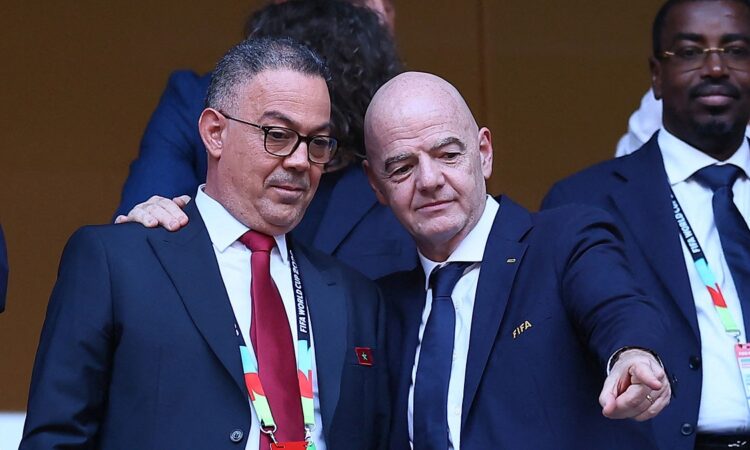 Royal Moroccan Football Federation president Fouzi Lekjaa stands with FIFA president Gianni Infantino in the stands before a match.