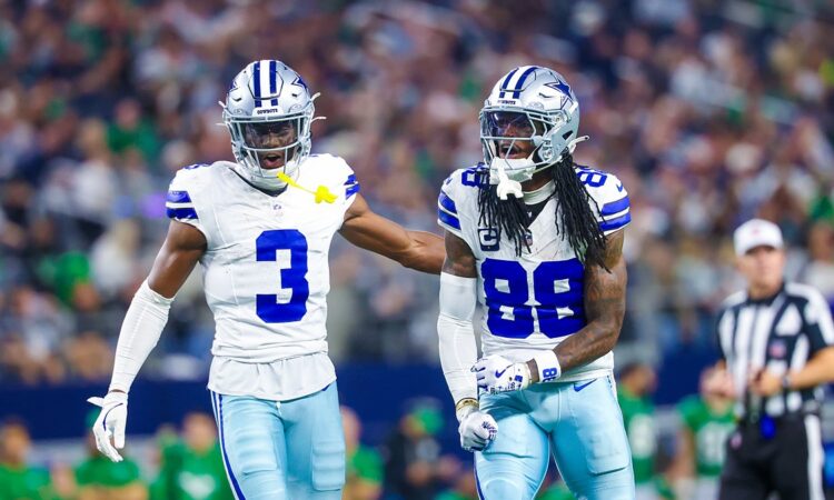Dallas Cowboys wide receiver George Pickens puts a hand on the back of teammate CeeDee Lamb, who yells and clenches his fists.