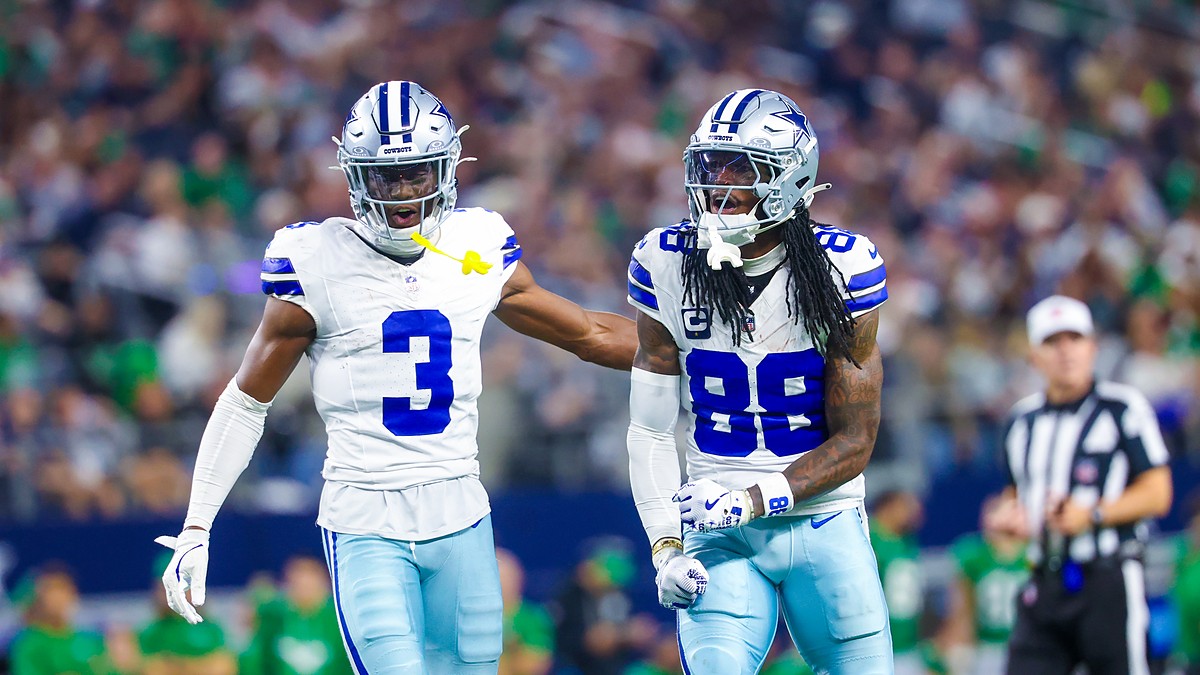 Dallas Cowboys wide receiver George Pickens puts a hand on the back of teammate CeeDee Lamb, who yells and clenches his fists.
